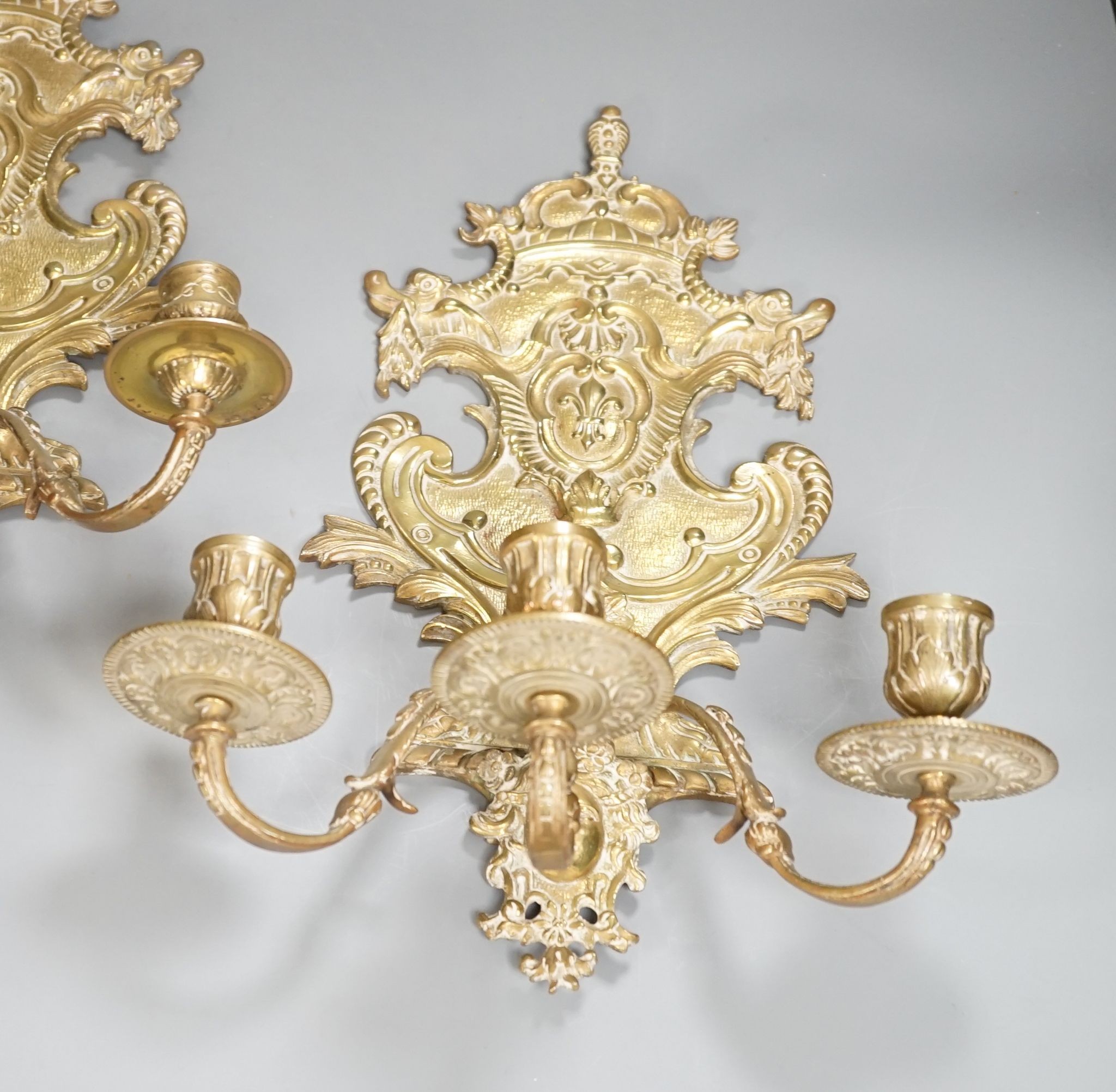 A pair of French ornate brass three branch wall sconces, 37 cms high